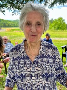 Nazair, Toni~ 2022, 07, 23 Glencoe, NB, with potato chips, husband Dave Eaton & her brother Georges in background- 02